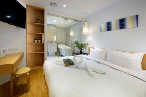 1 dormitorio con un perro blanco en la cama en Shin Sei Bashi Hotel en Taichung