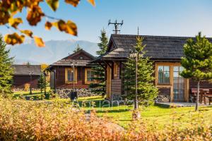 una casa de madera con un patio delante de ella en Aquamara Aquapark Tatralandia, en Liptovský Mikuláš