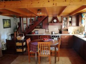 a kitchen with a table and chairs and a staircase at Roula House in Nýmfai