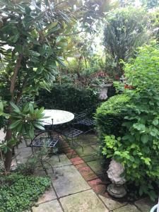 a table and chairs in a garden with plants at 10 st james villas in Winchester