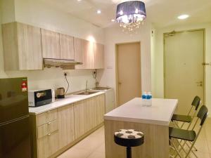 a kitchen with wooden cabinets and a kitchen island with a counter top at Makam Service Suites Times Square in Kuala Lumpur