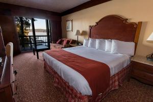 a hotel room with a large bed and a balcony at Lake Barkley State Resort Park in Cadiz