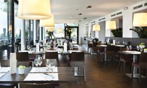 a restaurant with tables and chairs and windows at Schönberghof Spielberg in Spielberg