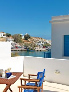 a balcony with a table and chairs and a view of the water at Psathi Blue Beta in Kimolos