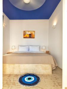 a bedroom with a bed with a blue ceiling at Psathi Blue Alpha in Kimolos