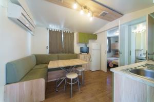 a kitchen and living room with a couch and a table at Centro Vacanze Camping Spinnaker in Marina Palmense