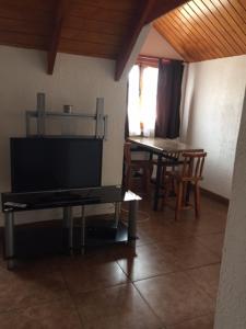 a living room with a tv and a table with chairs at Cabañas Aires del Bosque in Concón