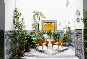 a patio with a table and chairs in a building with tiles at Mateo Alemán 22 in Seville