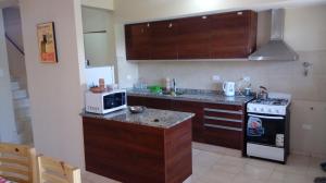 a small kitchen with a microwave and a stove at Duplex Kirara in Santa Lucía