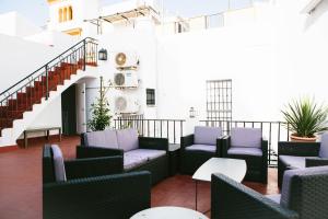 a balcony with chairs and tables and a staircase at Mateo Alemán 22 in Seville