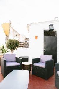 eine Terrasse mit 2 Stühlen und einem Tisch in der Unterkunft Mateo Alemán 22 in Sevilla