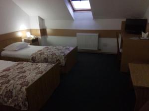 a hotel room with two beds and a window at Hotel Perla in Satu Mare