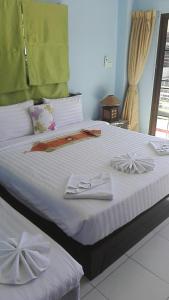 a bedroom with a bed with white sheets and bows at La Piccola Patong in Patong Beach