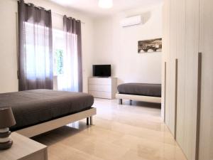 a bedroom with two beds and a television in it at Roema Guest House in Rome