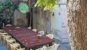 a wooden table and chairs in a yard with flowers at Lalghat Haveli in Udaipur