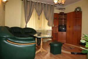 a living room with a black leather couch and a table at Комплекс отдыха "Престиж" in Boryspil