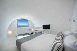 a bedroom with a bed and a desk at Apanemo Hotel & Suites in Akrotiri