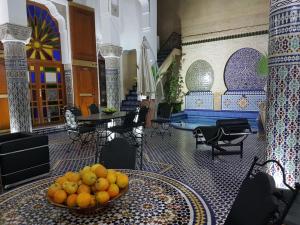 Riad Soleil d'Or في فاس: غرفة مع وعاء من البرتقال على طاولة