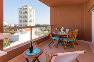 balcón con mesa y sillas y ventana grande en Beautiful Apartment Litoralmar, en Portimão