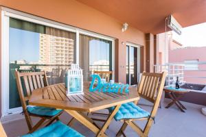 a wooden table and chairs on a balcony at Beautiful Apartment Litoralmar in Portimão