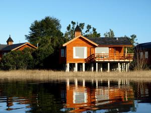 a house on the shore of a body of water at Gracias a la Vida Lodge in Puerto Varas