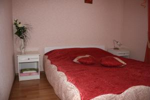 1 dormitorio con 1 cama roja y 2 almohadas en Комплекс отдыха "Престиж" en Boryspilʼ