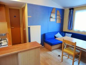 a blue living room with a blue couch and a table at Mobile-Home 1 "Ognon" in Pesmes
