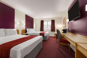 a hotel room with two beds and a desk at Days Inn Maidstone in Maidstone +20 photos