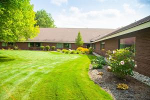 a house with a yard with green grass and flowers at Harrington Inn in Fremont