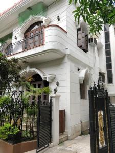a white house with a black gate in front of it at Khanna House in Kolkata