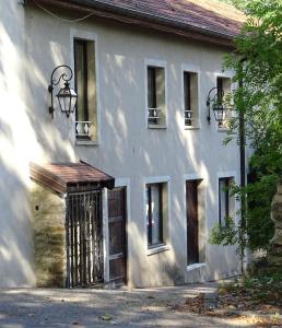 a white building with a gate and windows at Mobile-Home 1 "Ognon" in Pesmes