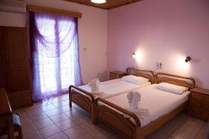 a bedroom with two beds and a window at Hotel Anna in Ammoudia