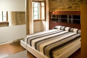 a bedroom with a bed with a striped blanket at Apartamentos Domus Stellae in Santiago de Compostela
