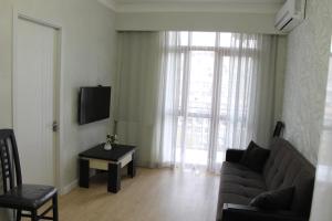 a living room with a couch and a table and a tv at Saburtalo Apartment in Tbilisi City
