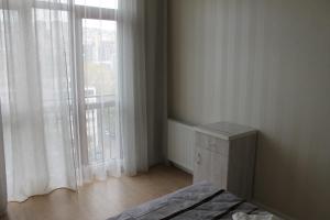 a bedroom with a bed and a large window at Saburtalo Apartment in Tbilisi City
