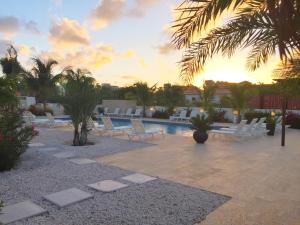 a group of white lounge chairs and a swimming pool at Las Islas Condo #1 in Palm-Eagle Beach