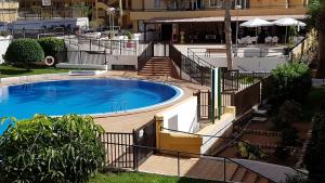 a large swimming pool with a wooden deck next to a building at Oliva Home in Los Cristianos