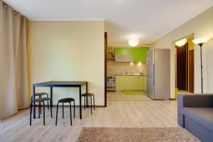 a living room with a table and chairs and a kitchen at Apartament 5 in Krakow