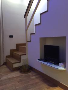 a living room with a tv and stairs at Appartamentino 116 Via Chiaia in Naples