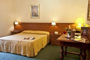 una camera d'albergo con letto e scrivania di Hotel Astoria Garden a Roma