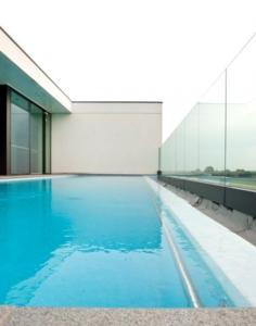 ein Pool mit blauem Wasser in einem Gebäude in der Unterkunft Blue Woods Hotel - Deerlijk in Deerlijk