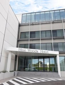 ein Gebäude mit einem Hotel-Schild aus blauem Holz davor in der Unterkunft Blue Woods Hotel - Deerlijk in Deerlijk