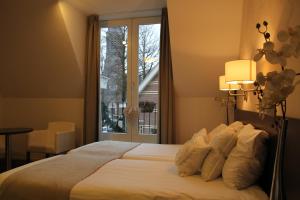 a bedroom with a bed and a window at Parkhotel Auberge Vincent in Nuenen