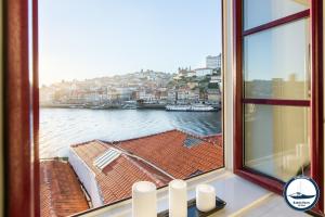 een raam met uitzicht op het water bij Douro Riverside Apartments in Vila Nova de Gaia