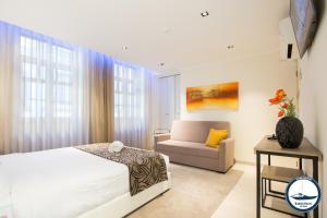 un dormitorio con una cama y un sofá en Douro Riverside Apartments, en Vila Nova de Gaia