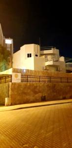ein Gebäude mit einem Zaun vor einer Straße in der Unterkunft City Suites in Eilat