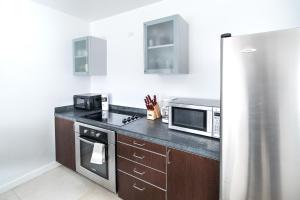 uma cozinha com um frigorífico e um micro-ondas em Sage on Ocean Drive Apartments em Miami Beach