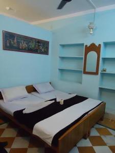 - une chambre avec un grand lit dans l'établissement Ganesh Guest House, à Jaisalmer