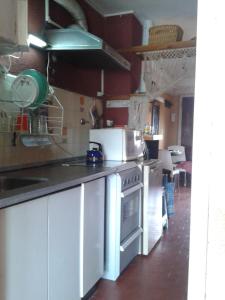 Una cocina con gabinetes blancos y un horno de estufa. en Braba III, en San Bernardo