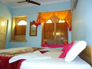 - une chambre avec un grand lit et des oreillers roses dans l'établissement Ganesh Guest House, à Jaisalmer